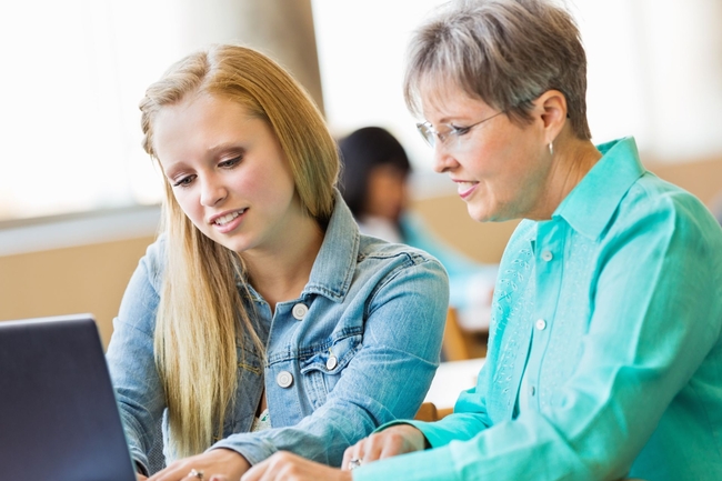 Seniorin, die eine Jugendliche beim Lernen unterstützt