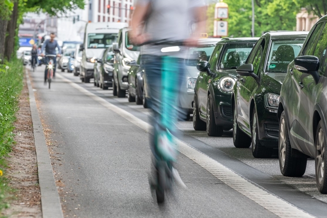 Radweg auf dem vorne ein E-Roller und weiter hinten ein Fahrrad fahren