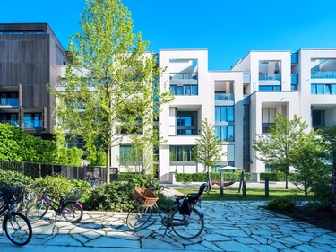 Eine Wohnsiedlung mit Fahrrädern und Begrünung