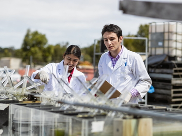 Zwei Wissenschaftler arbeiten draußen an einem Experiment