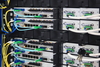 Ein Serverrack mit mehreren Netzwerkgeräten, die durch verschiedene farbige Kabel verbunden sind.