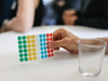 Eine Hand hält einen Zettel mit Klebepunkten für ein Meeting.